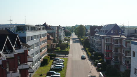 Aerial-drone-flying-forward-in-middle-of-Scharbeutz-streets,-German-house-buildings,-Germany,-day